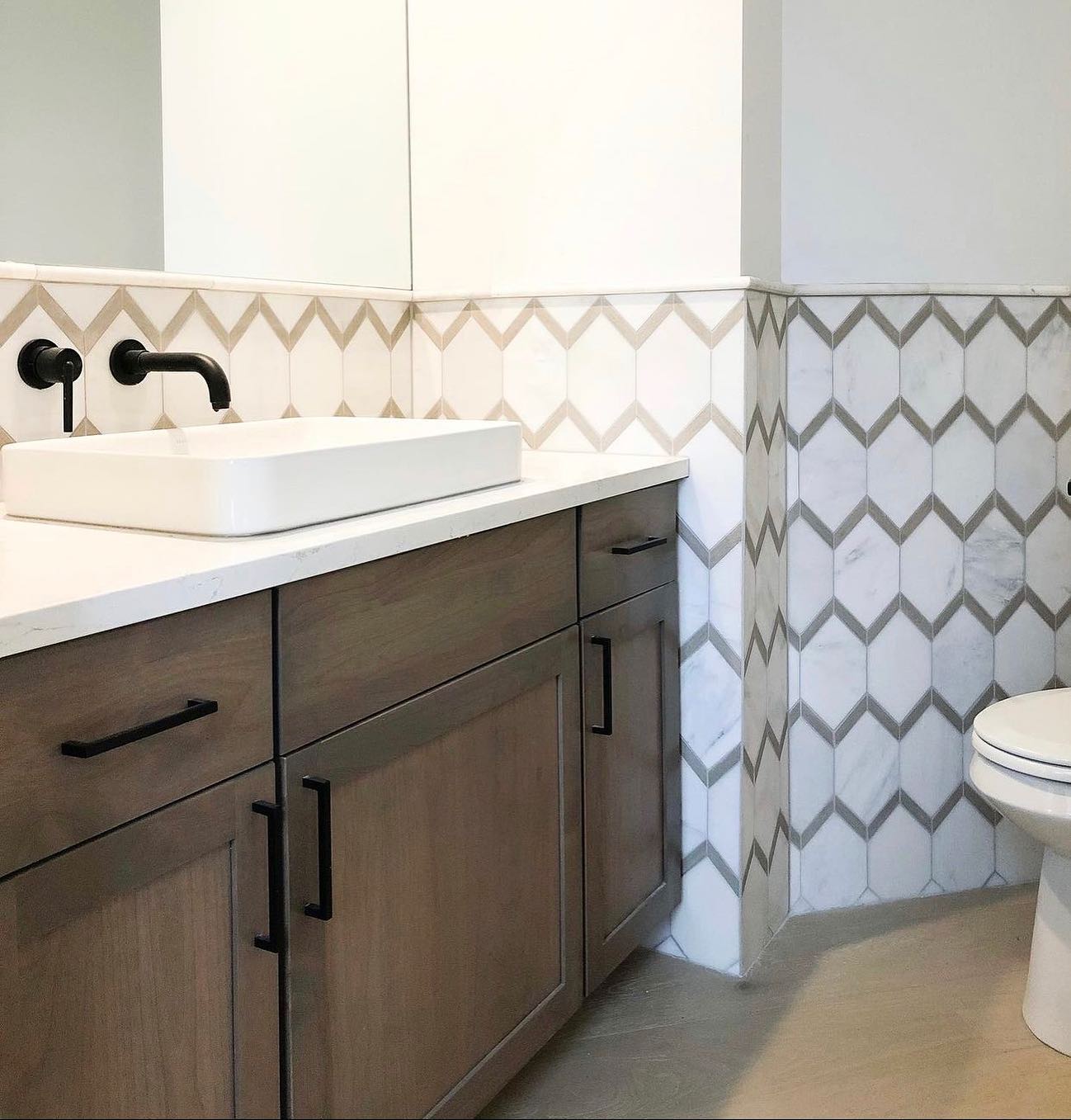 Make a statement with neutral tones. 🤩 Our Intrigue collection does just that in a design forward chevron pattern. Via @macadamfd #emsertile