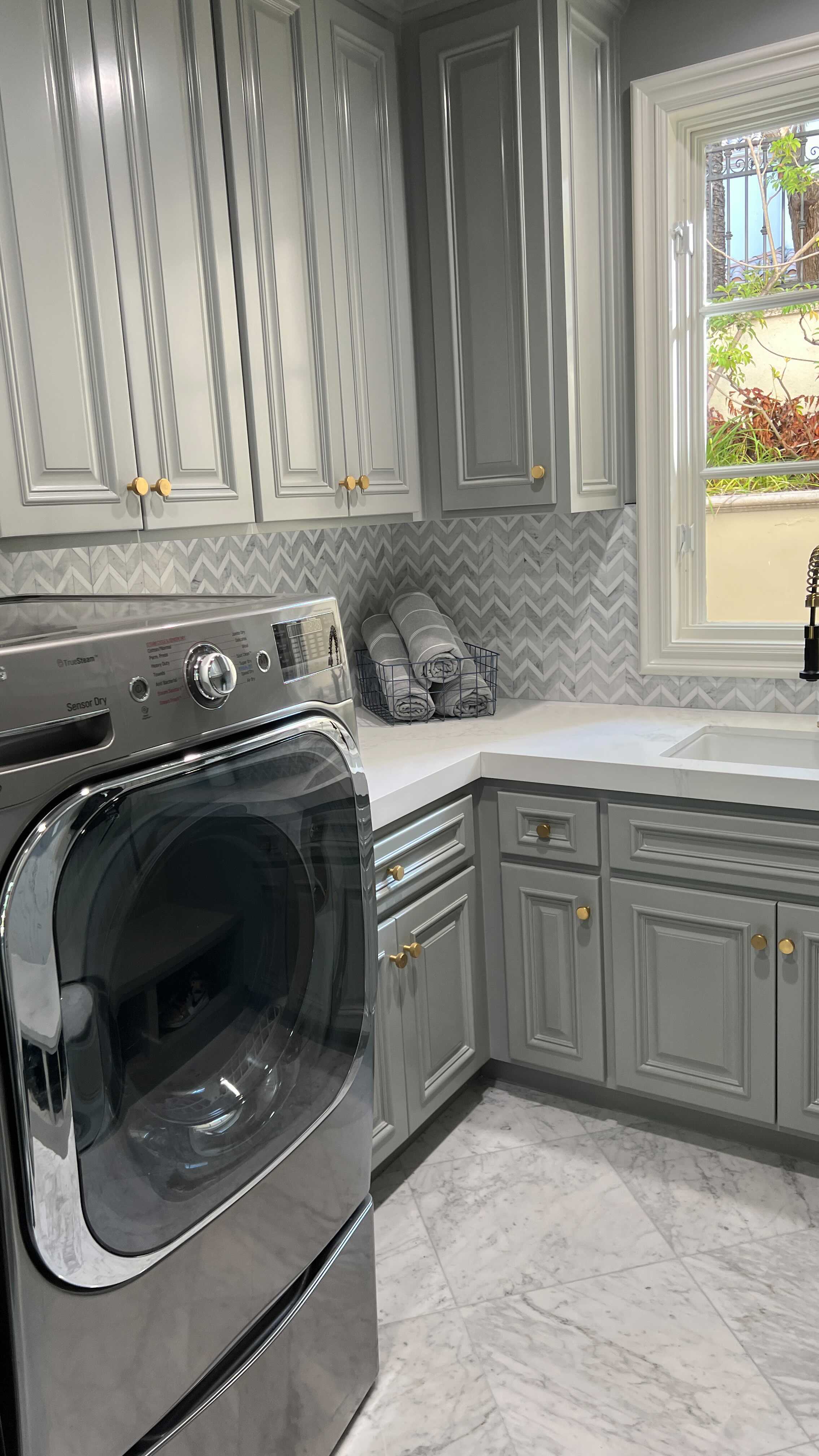 We are excited to share the 2nd project reveal in @oclydia and @ocdoug’s home makeover! Their new laundry room turned out beautiful with its timeless color palette and fun chevron backsplash from our Bizou collection. Also featuring our Bianco Gioia marble on the floors.  #emsertile